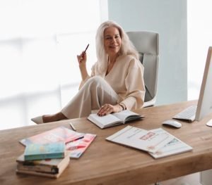 "Focused mature woman at modern workspace demonstrating mental clarity and sustained afternoon productivity