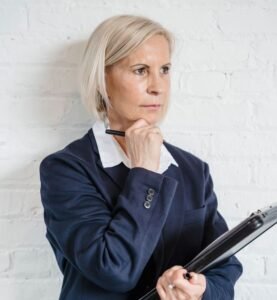 Woman in her 50s pausing to think, midlife wisdom.