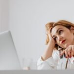 Woman over 50 losing focus under stress at her desk